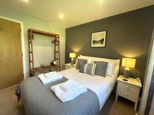 セント・オーステルにあるLuxurious 4 Bedroom New England Style Villa - Trewhiddle V14のベッドとタオル2枚のある寝室