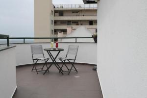 a balcony with a table and chairs on a building at Real Caparica Hotel in Costa da Caparica