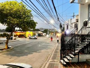 a woman walking down a street next to a building at Casa grande cerca a la playa in Ríohacha