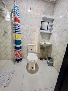 a bathroom with a toilet and a sink at Casa grande cerca a la playa in Ríohacha +4 photos