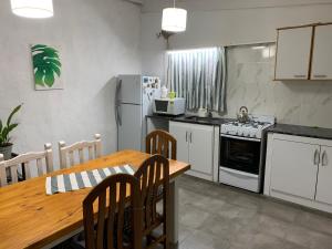 a kitchen with a wooden table and a refrigerator at Departamento Noe in Tandil