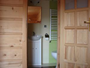 a bathroom with a sink and a toilet and a door at Pokoje u Małgorzatki in Murzasichle +32 photos
