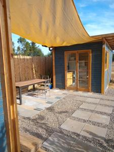 a patio with a bench and a table at Tiny House Casa Maqui in Cáhuil +5 photos