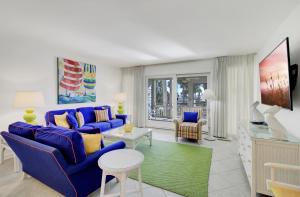 Una sala de estar con un sofá azul y una mesa. en Beach Club Villa 53 by Wild Dunes, Oceanfront, en Isle of Palms