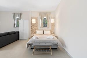 a bedroom with a bed and a couch at Orianthia Stone Houses in Marantochori