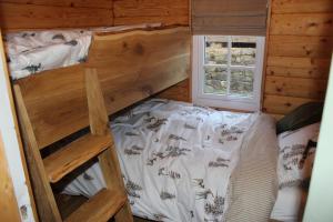 a bedroom with two bunk beds and a window at Beautifully Restored Log Cabin in Trawsfynydd
