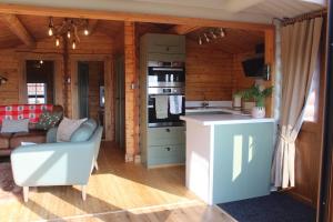 a kitchen and living room in a log cabin at Beautifully Restored Log Cabin in Trawsfynydd