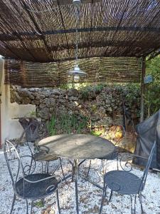 een tafel en stoelen in een patio met een plafond bij Notre Cabanon en Provence in Auriol
