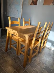 a wooden table with four chairs around it at Brada View Bamburgh in Bamburgh
