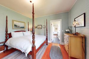 a bedroom with a four poster bed and a dresser at Sunny Hill Farmhouse in Fort Ward
