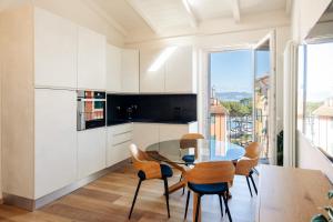 a kitchen with white cabinets and a table and chairs at CADAMARE charming rooms in Portovenere in La Spezia