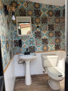 a bathroom with a toilet and a sink and a mirror at Casa con Alberca La Mexicana in La Calera +44 photos