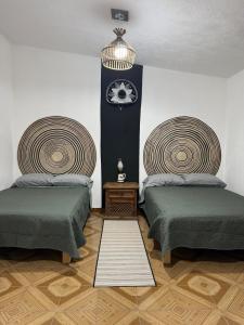 a room with two beds and a clock on the wall at Casa con Alberca La Mexicana in La Calera