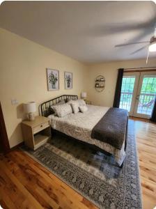 a bedroom with a bed and a table with a night stand at Busse's Roost Cozy Mountain House in Cosby