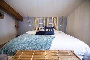 a bedroom with a large white bed with a blue blanket at Le Logis de la Gabirotte in Nieulle-sur-Seudre +68 photos