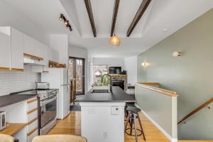 Una cocina con gabinetes blancos y encimera. en Initial - Hygge - MSA, en Beaupré