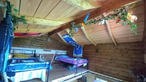 a room in a log cabin with two beds at Cabane du Druide Domaine de Fangorn in Glux