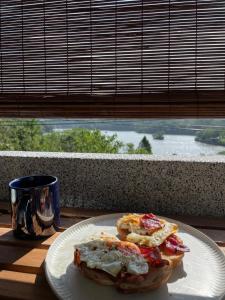 a plate with a breakfast sandwich on a table with a window at Mihu Mountain Bed and Breakfast 