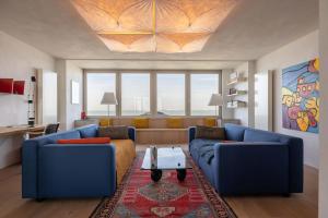 a living room with two blue couches and a table at Hello Zeeland - Appartement Port Scaldis 01-081 in Breskens