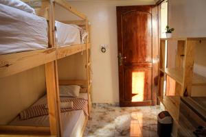 a room with two bunk beds and a door at Talia Surf Morocco in Taghazout