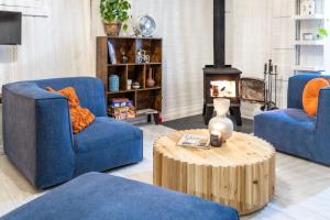 a living room with two blue chairs and a coffee table at Maison du Village - Nature Beach Bike & Village in Eastman