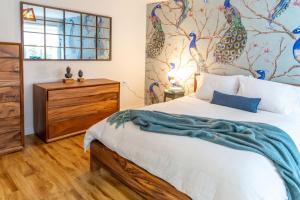 a bedroom with a bed and a painting of peacocks at Maison du Village - Nature Beach Bike & Village in Eastman