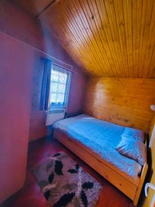 a bedroom with a bed with a wooden ceiling at Cabana Baile Chirui Ciubar in Băile Chirui
