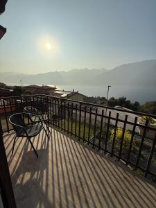 a bench on a balcony with a view of the water at Appartamento Riflessi D'Acqua in Navene +8 photos
