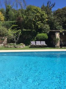 2 bancs installés à côté d'une piscine dans l'établissement Villa Saint Paul, à Saint-Paul-de-Vence