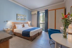 圣保罗湾城Xemxija Bay Hotel的一间带床和桌子的酒店房间