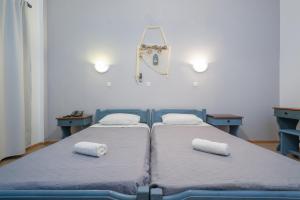two beds in a hospital room with towels on them at To Kyma in Moudhros