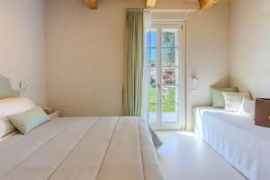 a bedroom with two beds and a window at Villa Petra in Capodarco