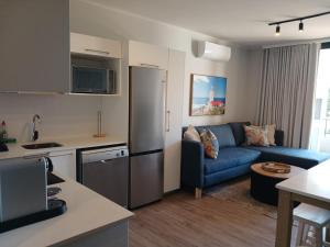 a kitchen and living room with a refrigerator and a couch at 105 Mossel Cove Unique & Trendy in Mossel Bay
