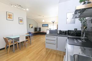 iFlat Pegli في جينوا: مطبخ مع طاولة وغرفة طعام