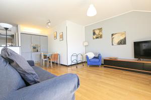 iFlat Pegli في جينوا: غرفة معيشة بها أريكة وجهاز تلفزيون