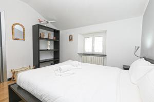 iFlat Pegli في جينوا: غرفة نوم مع سرير أبيض ورف أسود