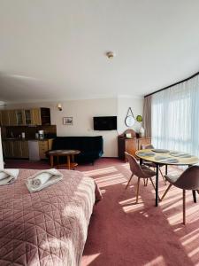 una habitación de hotel con una cama y una mesa en Apartamenty Baltic Sea 300 krokow od morza, en Kołobrzeg