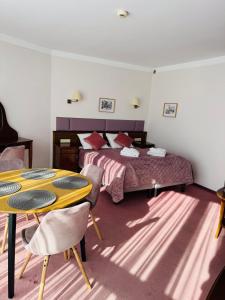1 dormitorio con 1 cama, mesa amarilla y sillas en Apartamenty Baltic Sea 300 krokow od morza, en Kołobrzeg