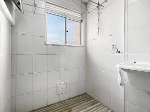a white bathroom with a sink and a window at Plaza Shopping Barbecue Court 3 bedrooms in Carapicuíba +11 photos