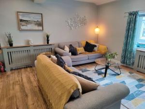 una sala de estar con un sofá y una mesa en Fabulous 2BD Maisonette Dunfermline, Fife, en Dunfermline