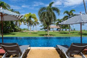 a resort pool with chairs and umbrellas at Beachfront! 2 Bedroom Apartment A4 - 110 Sqm in Ko Bu Bu