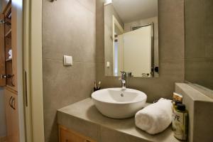 ein Badezimmer mit einem weißen Waschbecken und einem Spiegel in der Unterkunft Hydra's Ideal Accommodation in Hydra + 33 Fotos