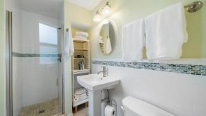a white bathroom with a sink and a mirror at Las Hermanas 4 in Longboat Key