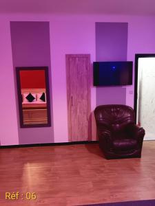 a living room with a leather chair and purple walls at Confort et détente en plein coeur de Rabat in Rabat