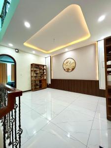 una grande camera con pavimento piastrellato bianco e orologio sul muro di Sea Home - Mui Ne Summerland 4br a Phan Thiet
