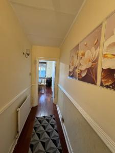 a hallway with two paintings on the wall and a staircase at Cozy room 7 in London +1 photo