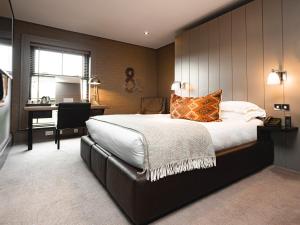 a bedroom with a large bed and a desk at Dakota Edinburgh in Queensferry