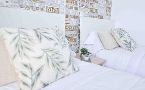 a bedroom with a white bed and a wall with photographs at El apartartamento de Santa Eva by Just Room in Miengo
