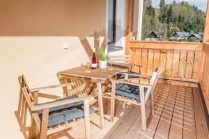 einen Holztisch und Stühle auf dem Balkon in der Unterkunft Apartment Angerer in Bad Aussee