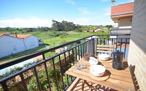 a balcony with a wooden table with bowls on it at El apartartamento de Santa Eva by Just Room in Miengo